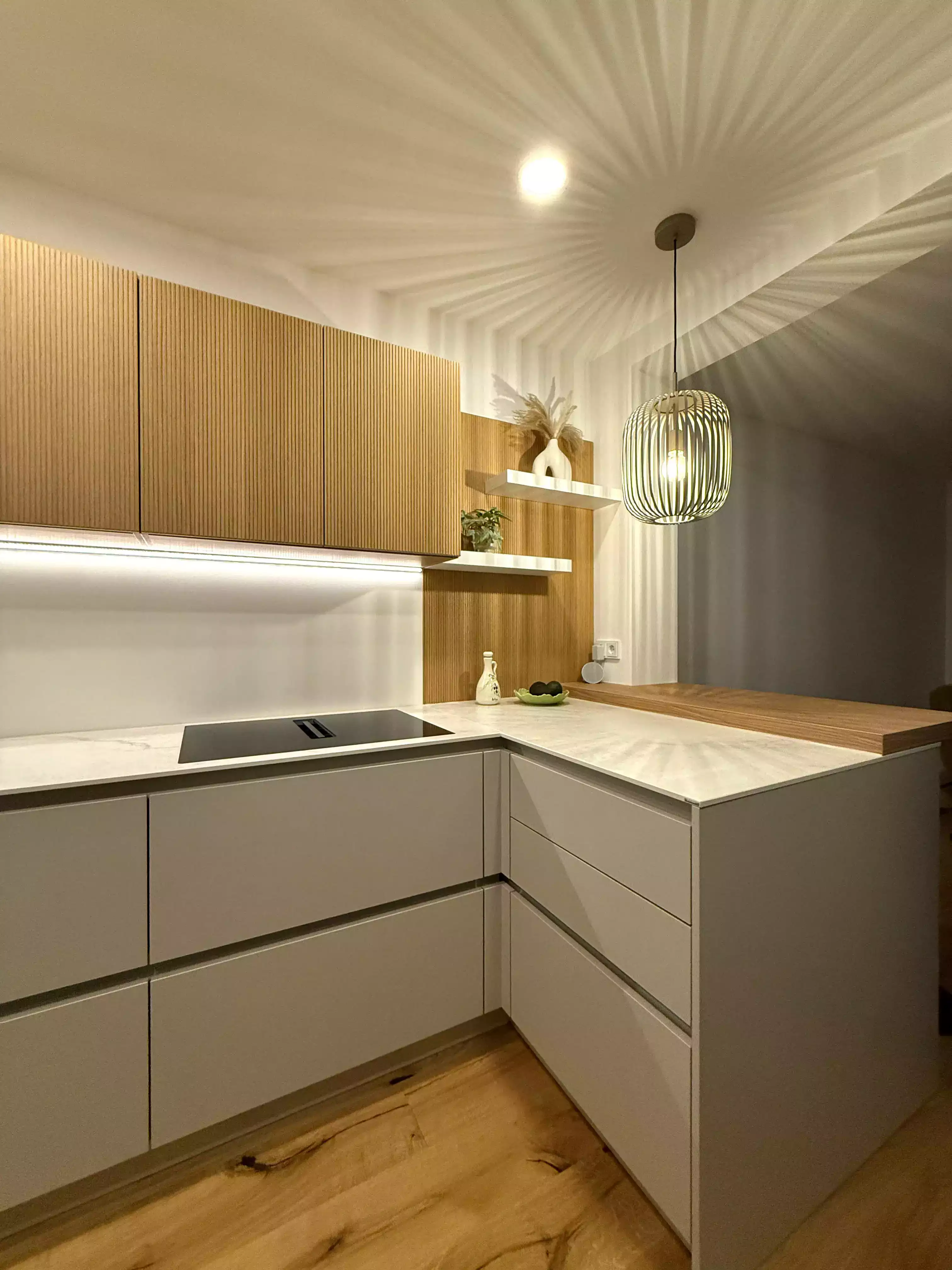 Moderne Küche mit Holzfronten, Marmorarbeitsplatte und stilvoller Hängelampe.